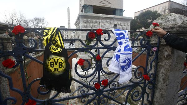 A man places a flower next to German football club scarves at the Obelisk of Theodosius, the scene of the suicide bomb attack, at Sultanahmet square in Istanbul, Turkey A man places a flower next to German football club scarves at the Obelisk of Theodosius, the scene of the suicide bomb attack, at Sultanahmet square in Istanbul, Turkey - Sputnik International