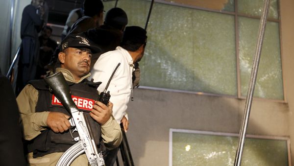 A paramilitary soldier stands guard at the ARY News offices as employees watch an attempt to remove shattered glass after a blast injured several people and caused property damage in Islamabad, Pakistan January 13, 2016. A paramilitary soldier stands guard at the ARY News offices as employees watch an attempt to remove shattered glass after a blast injured several people and caused property damage in Islamabad, Pakistan January 13, 2016. - Sputnik International