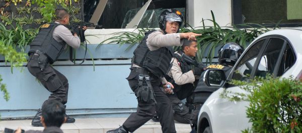Indonesian police take position and aim their weapons as they pursue suspects outside a cafe after a series of blasts hit the Indonesia capital Jakarta on January 14, 2016 - Sputnik International