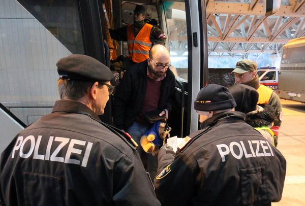 Austrian police officer check the identification documents of migrants before allowing them to get out a bus from Slovenia to cross the border from Slovenia into Austria, at a checkpoint at the Karawanks tunnel near Villach, Austria, Wednesday, Jan. 13, 2016. - Sputnik International