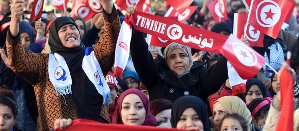 Tunisian women wave national flags and shout slogans on January 14, 2016, during a rally on Habib Bourguiba Avenue in Tunis to mark the fifth anniversary of the 2011 revolution. - Sputnik International