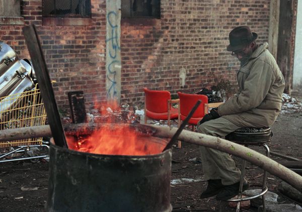 A homeless man sits by a barrel fire to keep warm near downtown Detroit. (File) - Sputnik International