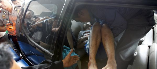 A man wounded in a gun and bomb attack in central Jakarta is helped from a car upon arrival at a hospital in Jakarta January 14, 2016 - Sputnik International