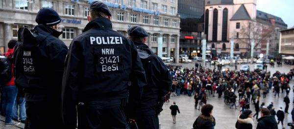 Policemen look on as refugees from Syria demonstrate against violence near the Cologne main train station in Cologne, western Germany on January 16, 2016 - Sputnik International