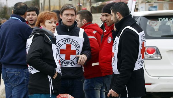 In this Monday, Jan. 11, 2016 photo, aid workers stand near a convoy of vehicles loaded with food and other supplies organized by the International Committee of the Red Cross, working alongside the Syrian Arab Red Crescent and the United Nations, makes it's way to the besieged town of Madaya, about 15 miles (24 kilometers) northwest of Damascus, Syria - Sputnik International
