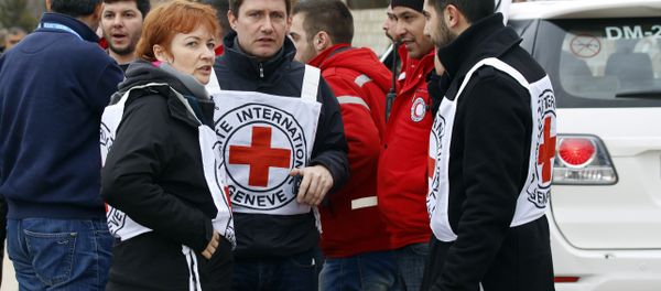 In this Monday, Jan. 11, 2016 photo, aid workers stand near a convoy of vehicles loaded with food and other supplies organized by the International Committee of the Red Cross, working alongside the Syrian Arab Red Crescent and the United Nations, makes it's way to the besieged town of Madaya, about 15 miles (24 kilometers) northwest of Damascus, Syria In this Monday, Jan. 11, 2016 photo, aid workers stand near a convoy of vehicles loaded with food and other supplies organized by the International Committee of the Red Cross, working alongside the Syrian Arab Red Crescent and the United Nations, makes it's way to the besieged town of Madaya, about 15 miles (24 kilometers) northwest of Damascus, Syria - Sputnik International