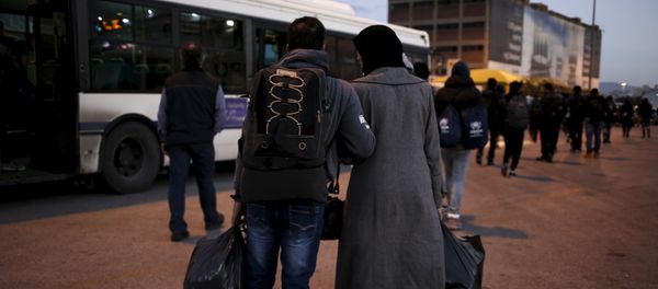A Syrian refugee couple carry their belongings as refugees and migrants arrive aboard the passenger ferry Nissos Rodos at the port of Piraeus, near Athens, Greece, January 13, 2016 A Syrian refugee couple carry their belongings as refugees and migrants arrive aboard the passenger ferry Nissos Rodos at the port of Piraeus, near Athens, Greece, January 13, 2016 - Sputnik International