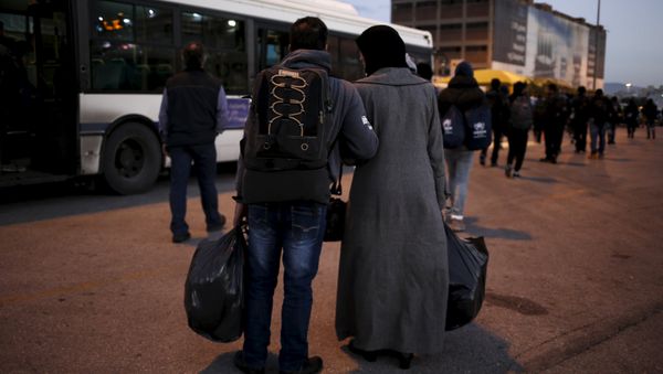 A Syrian refugee couple carry their belongings as refugees and migrants arrive aboard the passenger ferry Nissos Rodos at the port of Piraeus, near Athens, Greece, January 13, 2016 A Syrian refugee couple carry their belongings as refugees and migrants arrive aboard the passenger ferry Nissos Rodos at the port of Piraeus, near Athens, Greece, January 13, 2016 - Sputnik International