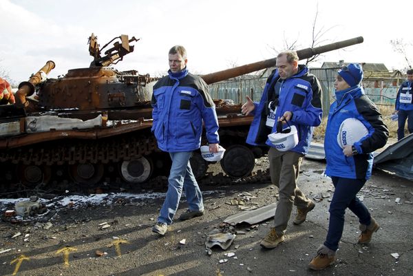 Deputy Chief of the OSCE's Special Monitoring Mission to Ukraine Alexander Hug (L), with members of the mission, walks past a burnt tank as he inspects an area between DPR forces and Ukrainian government troops in the village of Kominternove north-east of the port city of Mariupol, Ukraine, January 15, 2016 Deputy Chief of the OSCE's Special Monitoring Mission to Ukraine Alexander Hug (L), with members of the mission, walks past a burnt tank as he inspects an area between DPR forces and Ukrainian government troops in the village of Kominternove north-east of the port city of Mariupol, Ukraine, January 15, 2016 - Sputnik International