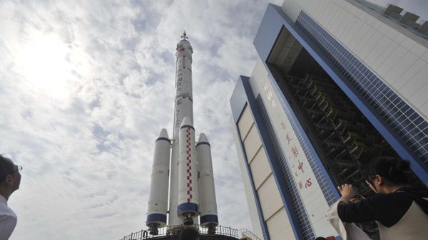 This file photo taken on September 20, 2008 shows Chinese tourists gathering to watch the Shenzhou-7 manned spaceship on top of the Long-March II-F rocket being transfered to the launchpad at the Jiuquan Satellite Launch Center in northwest China's Gansu province - Sputnik International