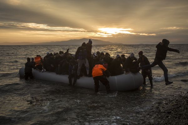 Refugees and migrants disembark on a beach after crossing a part of the Aegean sea from the Turkey's coast to the northeastern Greek island of Lesbos, on Sunday, Jan. 3, 2016 - Sputnik International