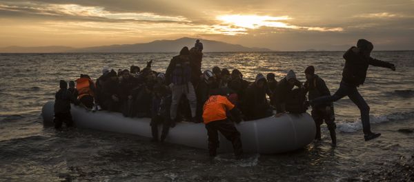 Refugees and migrants disembark on a beach after crossing a part of the Aegean sea from the Turkey's coast to the northeastern Greek island of Lesbos, on Sunday, Jan. 3, 2016 - Sputnik International
