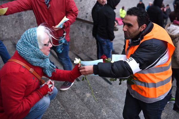 Refugees from Syria present flowers to passers-by as they demonstrate against violence near the Cologne main train station in Cologne, western Germany on January 16, 2016, where hundreds of women were groped and robbed in a throng of mostly Arab and North African men during New Year's festivities - Sputnik International