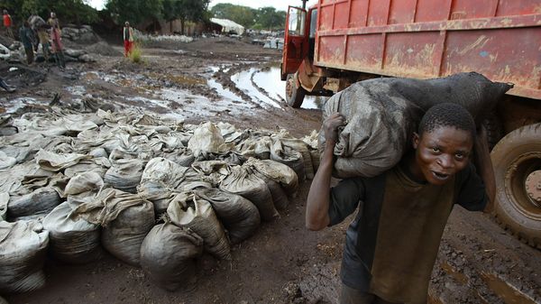 A young man carries wet cobalt on his back at the Shinkolobwe mine, about 35km from the town of Likasi in the Democratic Republic of the Congo, Saturday, 10 April 2004. - Sputnik International
