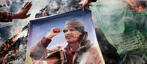 Benghazi residents burn portraits of Muammar Gaddafi, banners with his quotes and his Green Book Benghazi residents burn portraits of Muammar Gaddafi, banners with his quotes and his Green Book - Sputnik International