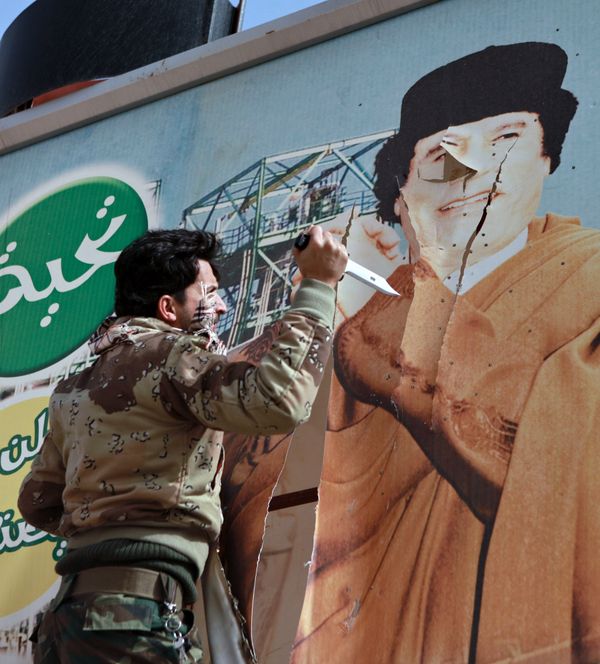 Libyan opposition supporter uses knife to cut a poster of Muammar Gaddafi in the captured rebel town of Ras Lanuf in the east of the country Libyan opposition supporter uses knife to cut a poster of Muammar Gaddafi in the captured rebel town of Ras Lanuf in the east of the country - Sputnik International