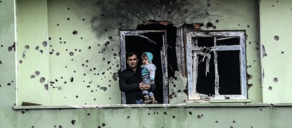 A man holding an infant stands on the balcony of a damaged house, after curfew ended in the southeastern Turkish town of Silopi on January 19, 2016 A man holding an infant stands on the balcony of a damaged house, after curfew ended in the southeastern Turkish town of Silopi on January 19, 2016 - Sputnik International