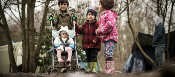 Young migrants or refugees walk with a stroller on December 29, 2015 in a camp in Grande-Synthe. - Sputnik International