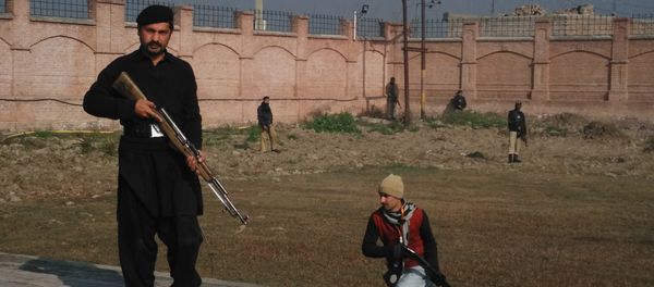 This photograph taken from a mobile phone shows Pakistani security personnel taking position outside the Bacha Khan university following an attack by gunmen in Charsadda, about 50 kilometres from Peshawar, on January 20, 2016 - Sputnik International