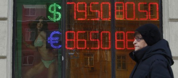 A woman walks past a board showing currency exchange rates of the U.S. dollar and euro against the rouble in Moscow, Russia, January 20, 2016 - Sputnik International