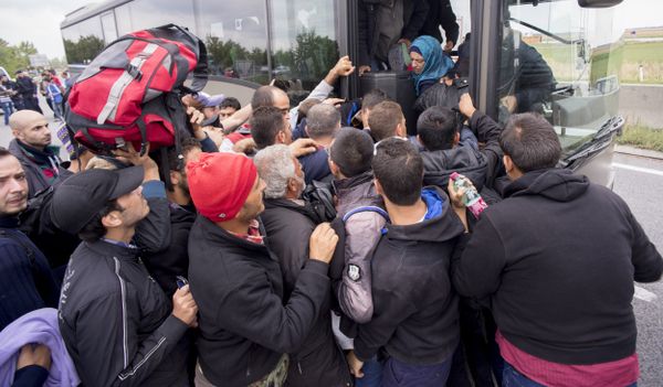 Migrants struggle to board a bus sent to pick them up on the closed highway A4 towards Vienna at the Austrian side of the border between Hungary and Austria on September 11, 2015 near Nickelsdorf, Austria. - Sputnik International