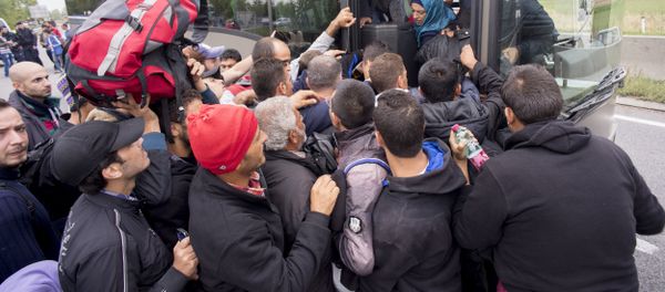 Migrants struggle to board a bus sent to pick them up on the closed highway A4 towards Vienna at the Austrian side of the border between Hungary and Austria on September 11, 2015 near Nickelsdorf, Austria Migrants struggle to board a bus sent to pick them up on the closed highway A4 towards Vienna at the Austrian side of the border between Hungary and Austria on September 11, 2015 near Nickelsdorf, Austria - Sputnik International