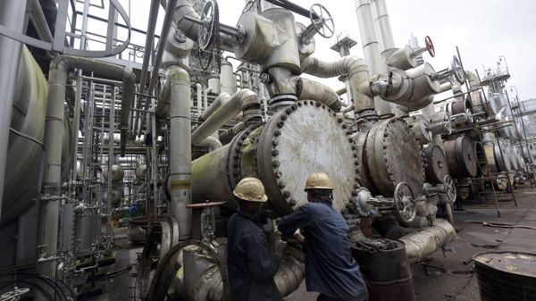 A picture taken on September 16, 2015 shows workers trying to tie a pipe of the first refinery in Nigeria, which was built in 1965 in oil rich Port Harcourt, Rivers State - Sputnik International