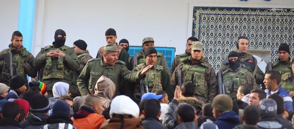 An army soldier tries to disperse protesters as he stands guard with his comrades outside the local government office during a protest in Kasserine, Tunisia January 22, 2016. An army soldier tries to disperse protesters as he stands guard with his comrades outside the local government office during a protest in Kasserine, Tunisia January 22, 2016. - Sputnik International