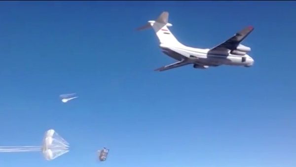 Syrian Air Force aircraft dropping humanitarian cargo on Russian parachute platforms in the area of Deir ez-Zor, Syria. - Sputnik International