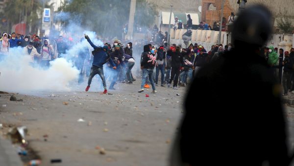 A protester throws a tear gas canister back toward police during a protest outside the local government office in Kasserine, Tunisia January 21, 2016. A protester throws a tear gas canister back toward police during a protest outside the local government office in Kasserine, Tunisia January 21, 2016. - Sputnik International