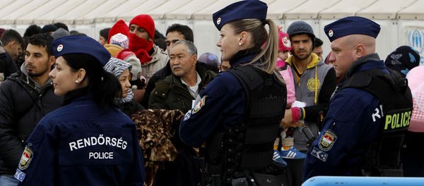 Hungarian police officers keep order as migrants wait to board a train towards Serbia. Hungarian police officers keep order as migrants wait to board a train towards Serbia. - Sputnik International