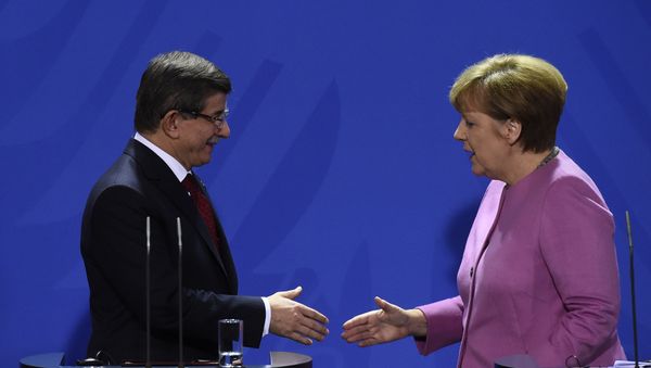 German Chancellor Angela Merkel (R) and Turkish Prime Minister Ahmet Davutoglu (L) shake hands during the press conference, after a meeting at the Chancellery, in Berlin on January 22, 2016 German Chancellor Angela Merkel (R) and Turkish Prime Minister Ahmet Davutoglu (L) shake hands during the press conference, after a meeting at the Chancellery, in Berlin on January 22, 2016 - Sputnik International
