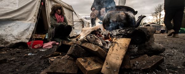 Migrants get warm around a brazier in the migrants camp of Grande-Synthe, near Dunkirk Migrants get warm around a brazier in the migrants camp of Grande-Synthe, near Dunkirk - Sputnik International