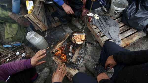 Migrants prepare their food outside shelters in a muddy field called the Grande-Synthe jungle, near Dunkirk, northern France Migrants prepare their food outside shelters in a muddy field called the Grande-Synthe jungle, near Dunkirk, northern France - Sputnik International
