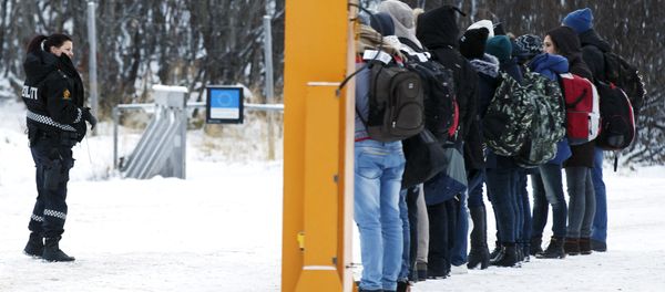 Migrants receive instructions from a Norwegian police officer at Storskog boarder crossing station near Kirkenes, after crossing the boarder between Norway and Russia on November 16, 2015 Migrants receive instructions from a Norwegian police officer at Storskog boarder crossing station near Kirkenes, after crossing the boarder between Norway and Russia on November 16, 2015 - Sputnik International