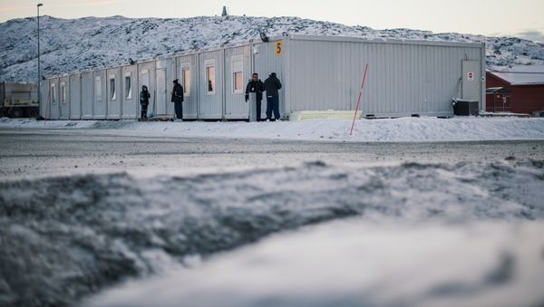 Refugees stand in front of residential containers at the arrival centre for refugees near the town on Kirkenes, northern Norway, close to the Russian - Norwegian border on November 12, 2015 Refugees stand in front of residential containers at the arrival centre for refugees near the town on Kirkenes, northern Norway, close to the Russian - Norwegian border on November 12, 2015 - Sputnik International