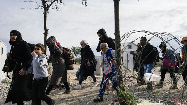 Migrants and refugees cross the Greek-Macedonian border near Gevgelija on November 15, 2015 - Sputnik International