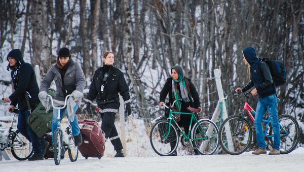 Refugees walk alongside there bikes to the Norwegian border crossing station at Storskog after crossing the border from Russia on November 12, 2015 near Kirkenes Refugees walk alongside there bikes to the Norwegian border crossing station at Storskog after crossing the border from Russia on November 12, 2015 near Kirkenes - Sputnik International