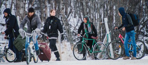 Refugees walk alongside there bikes to the Norwegian border crossing station at Storskog after crossing the border from Russia on November 12, 2015 near Kirkenes - Sputnik International