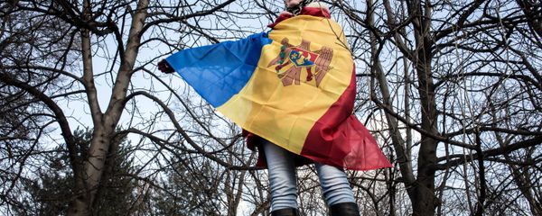 A participant in an opposition rally in Chisinau wrapped in Moldova's national banner - Sputnik International