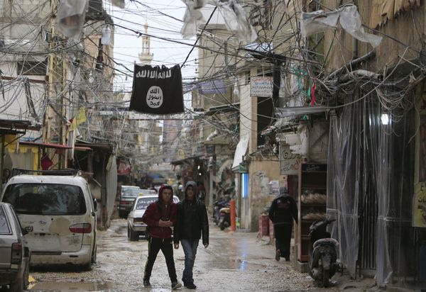 Youth walk under an Islamic State flag in Ain al-Hilweh Palestinian refugee camp, near the port-city of Sidon, southern Lebanon January 19, 2016 - Sputnik International