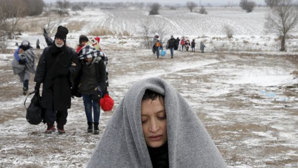 Migrants walk through a frozen field after crossing the border from Macedonia, near the village of Miratovac, Serbia, January 18, 2016. Migrants walk through a frozen field after crossing the border from Macedonia, near the village of Miratovac, Serbia, January 18, 2016. - Sputnik International