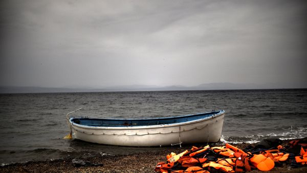 Life jackets and a boat that were used by refugees and migrants to cross the Aegean sea from Turkey lie abandoned on a beach on the Greek Island of Lesbos on October 8, 2015. - Sputnik International