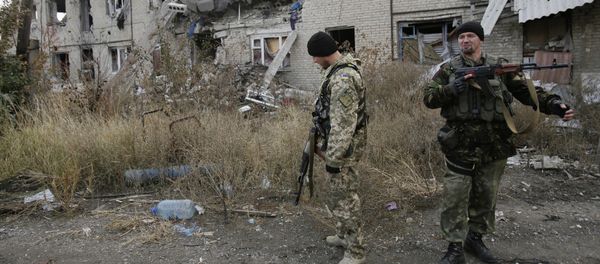 Ukrainian servicemen walks in the yard of a destroyed building in the Pisky village near Donetsk on October 26, 2015 - Sputnik International