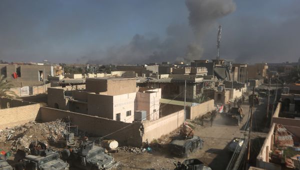 Members of Iraq's elite counter-terrorism service patrol as smoke billows in the background following a reported air strike by the US-led coalition on December 29, 2015 - Sputnik International