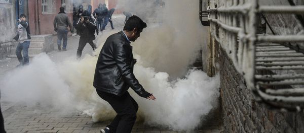 People react as tear gas is sprayed during clashes with Turkish police at the Sur district in Diyarbakir, on January 3, 2016 - Sputnik International