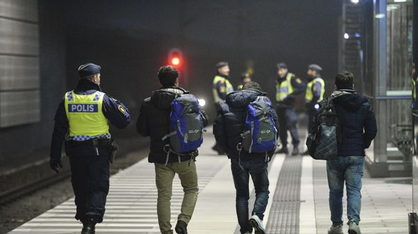 A police officer escorts migrants from a train at Hyllie station outside Malmo, Sweden. Picture taken November 19, 2015 A police officer escorts migrants from a train at Hyllie station outside Malmo, Sweden. Picture taken November 19, 2015 - Sputnik International