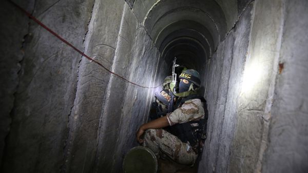Palestinian militants from the Islamic Jihad's armed wing, the Al-Quds Brigades, squat in a tunnel, used for storing weapons, as they take part in military training in the south of the Gaza Strip on March 3, 2015 - Sputnik International