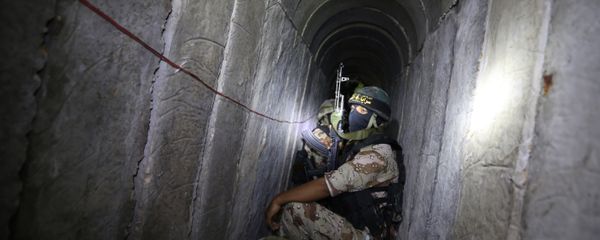 Palestinian militants from the Islamic Jihad's armed wing, the Al-Quds Brigades, squat in a tunnel, used for storing weapons, as they take part in military training in the south of the Gaza Strip on March 3, 2015 - Sputnik International