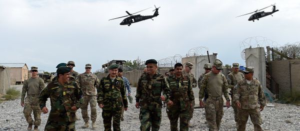 US army and Afghan National Army (ANA) soldiers walk as a NATO helicopter flies overhead US army and Afghan National Army (ANA) soldiers walk as a NATO helicopter flies overhead - Sputnik International